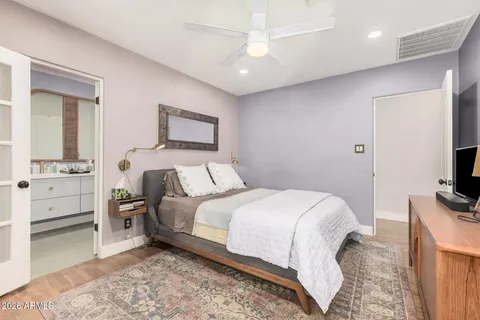 a spacious bedroom with a bed and a flat screen tv