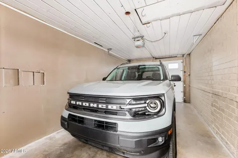a front view of a house with a garden and trees