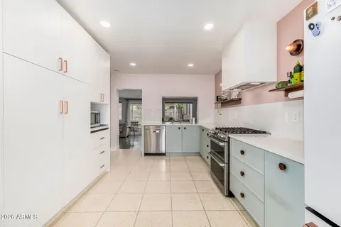 a kitchen with white cabinets and sink
