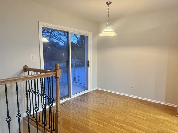 a view of a hallway with wooden floor and a chandelier