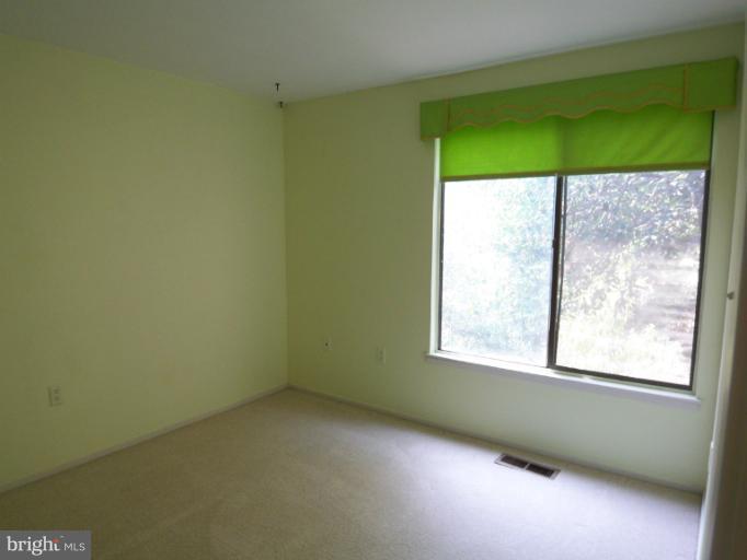 a view of a room that has a window and a ceiling fan