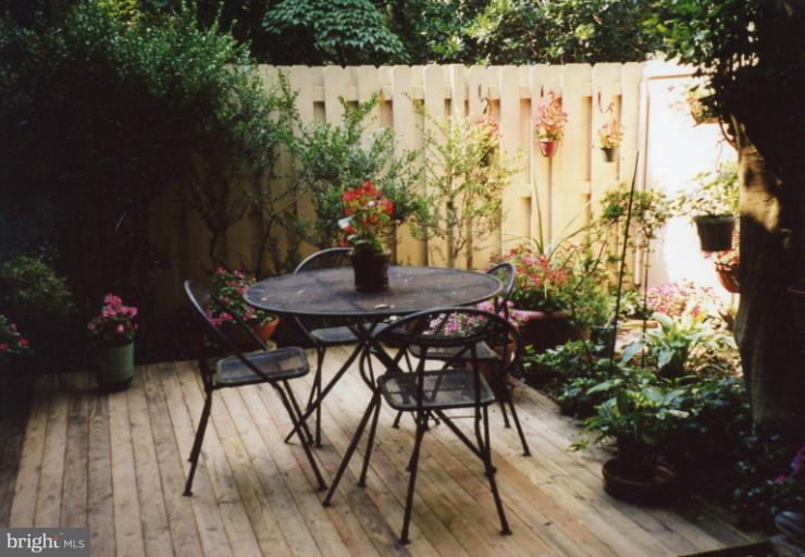 11080 Saffold Way Reston, VA 20190 - Photo 28 of 30 a backyard with table and chairs with potted plants