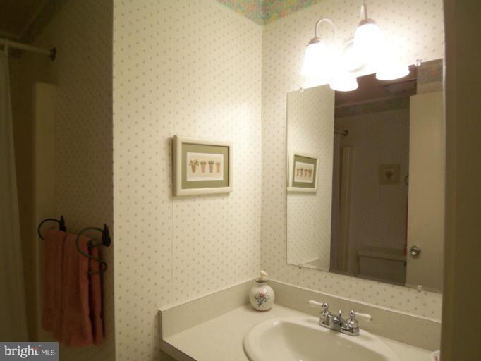 11080 Saffold Way Reston, VA 20190 - Photo 8 of 30 a bathroom with a sink and mirror