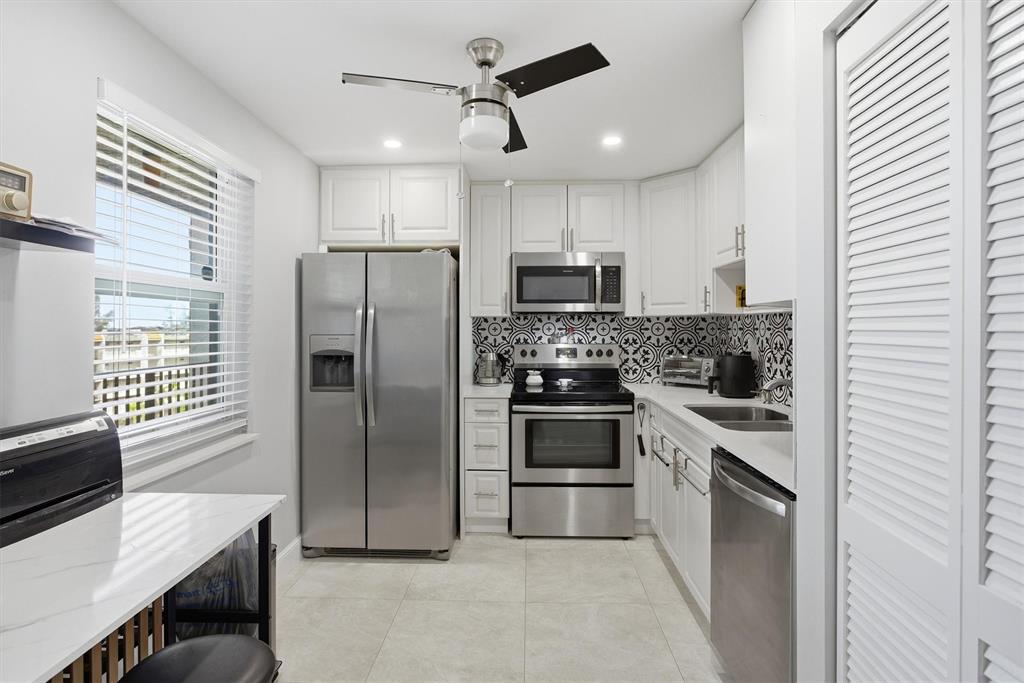 3910 Inverrary Boulevard, Unit 708B Lauderhill, FL 33319 - Photo 14 of 58 a kitchen with kitchen island a counter top space stainless steel appliances and cabinets