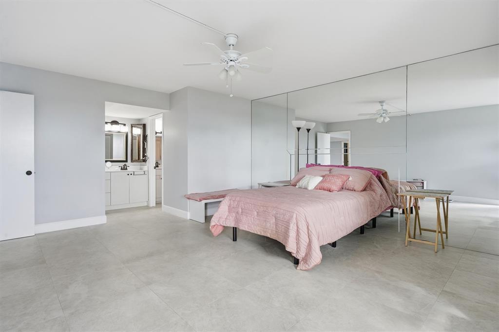 3910 Inverrary Boulevard, Unit 708B Lauderhill, FL 33319 - Photo 19 of 58 a spacious bedroom with a bed and a chandelier