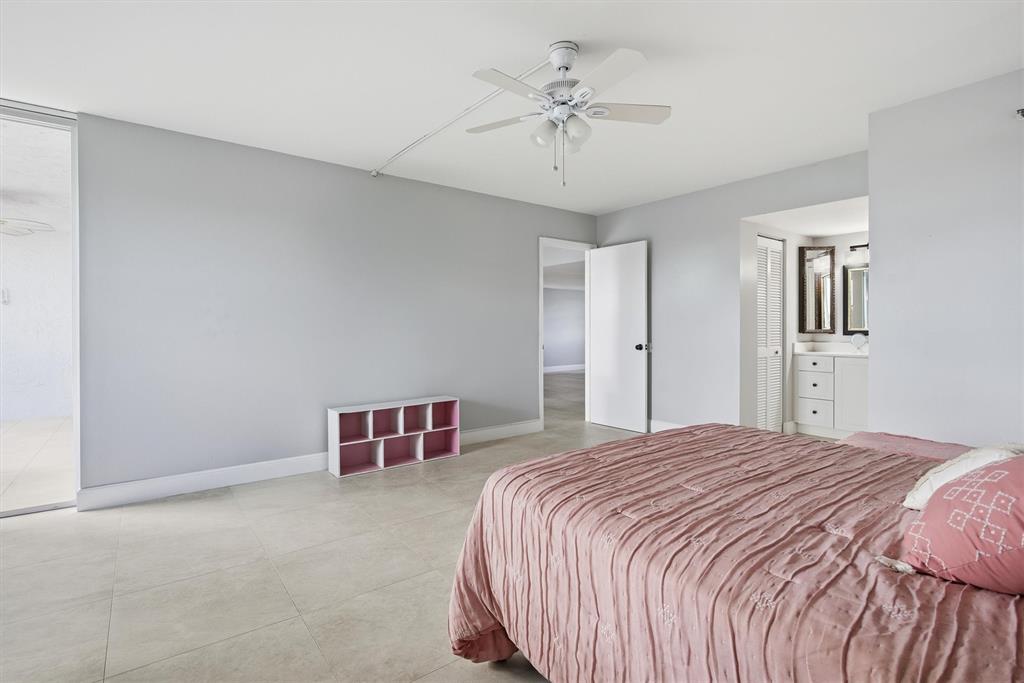 3910 Inverrary Boulevard, Unit 708B Lauderhill, FL 33319 - Photo 20 of 58 a bedroom with a bed and a chandelier