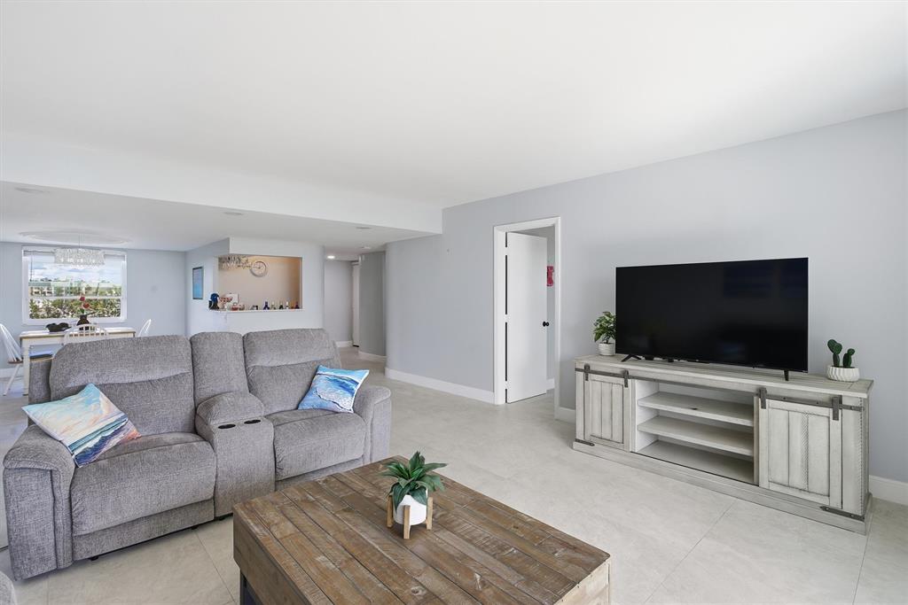 3910 Inverrary Boulevard, Unit 708B Lauderhill, FL 33319 - Photo 10 of 58 a living room with furniture and a flat screen tv