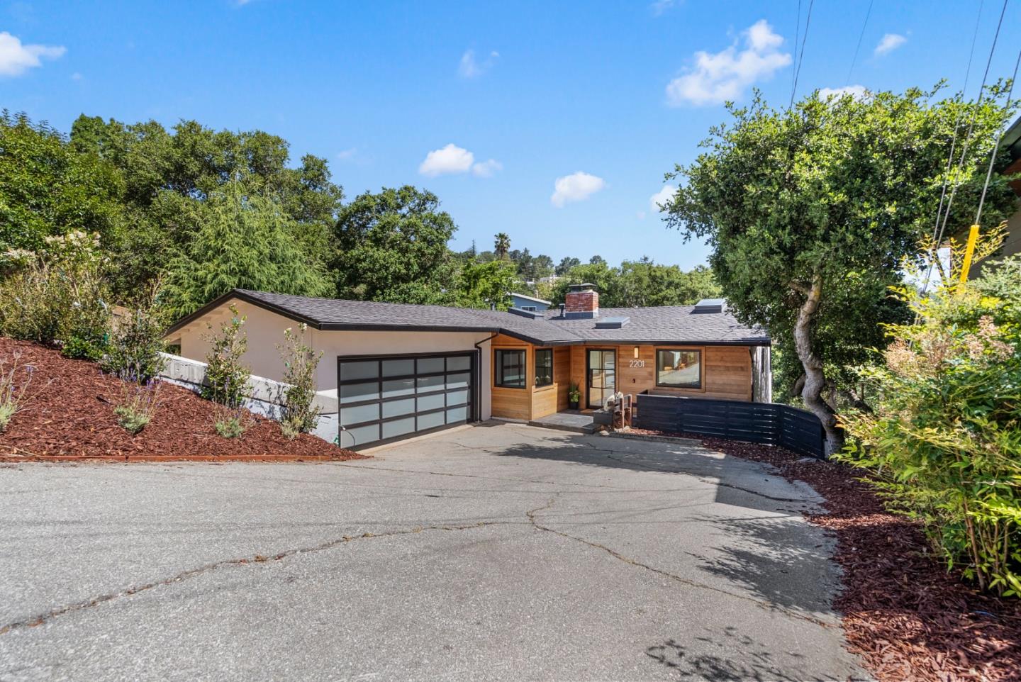 a view of a house with a yard and potted plants