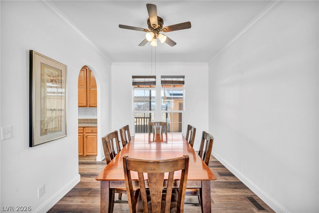 225 California Street Searchlight, NV 89046 - Photo 19 of 64 A classic wooden dining set anchors this bright space, featuring a ceiling fan and a view to the outdoors.
