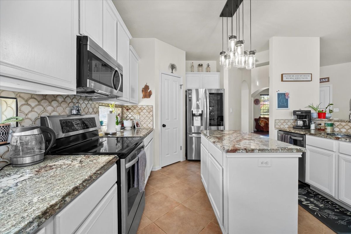 455 Logan Road Georgetown, TX 78628 - Photo 11 of 35 a kitchen with stainless steel appliances granite countertop a sink stove and refrigerator