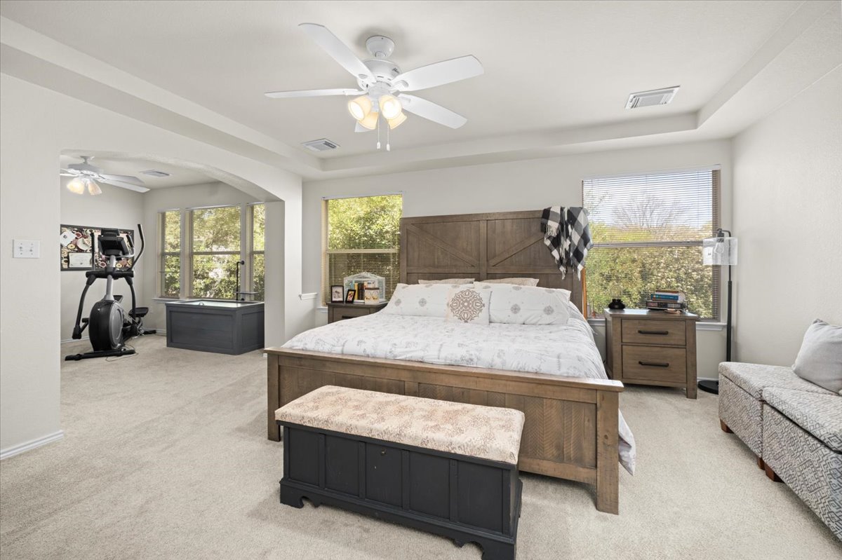 455 Logan Road Georgetown, TX 78628 - Photo 16 of 35 a bedroom with a large bed and a chandelier