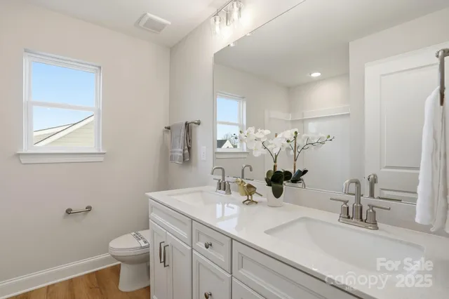 a bathroom with a granite countertop sink a toilet and a mirror