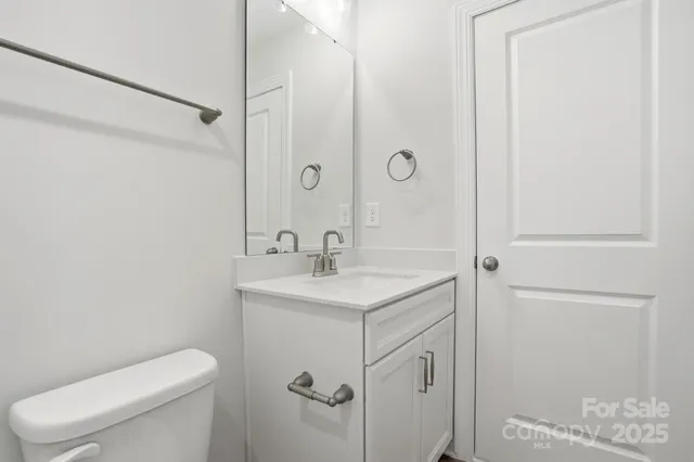 a bathroom with a toilet sink vanity and shower
