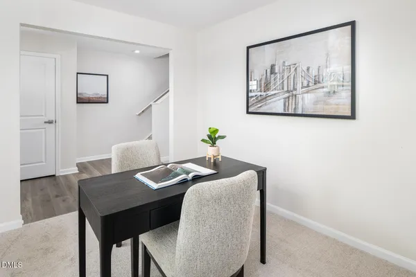 a living room with stainless steel appliances furniture dining table and wooden floor