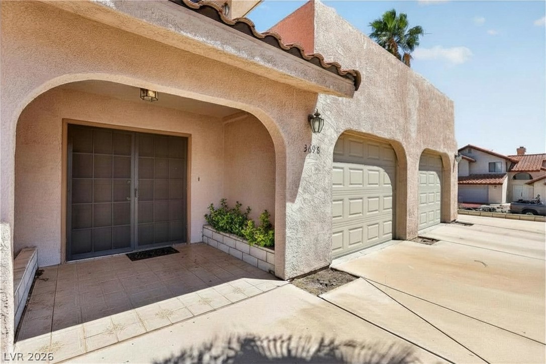 3698 Laughlin Boulevard Laughlin, NV 89029 - Photo 10 of 49 A charming stucco exterior features an inviting arched entry and dual garage doors.