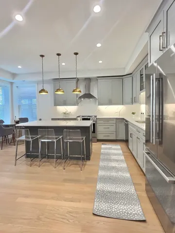 a kitchen with stainless steel appliances granite countertop a stove a sink and a refrigerator