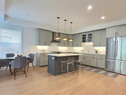 a large kitchen with kitchen island a sink a stove a dining table and chairs