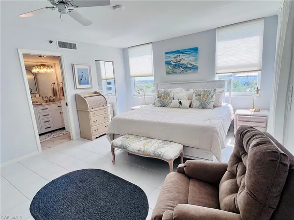 a bedroom with furniture and a large window