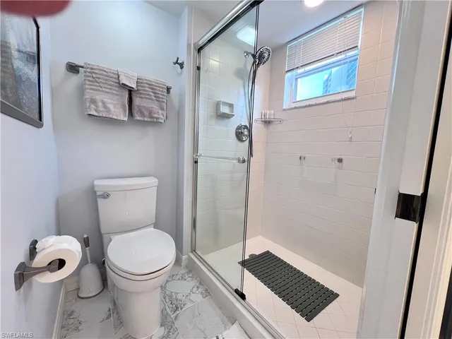 a bathroom with a toilet and a shower
