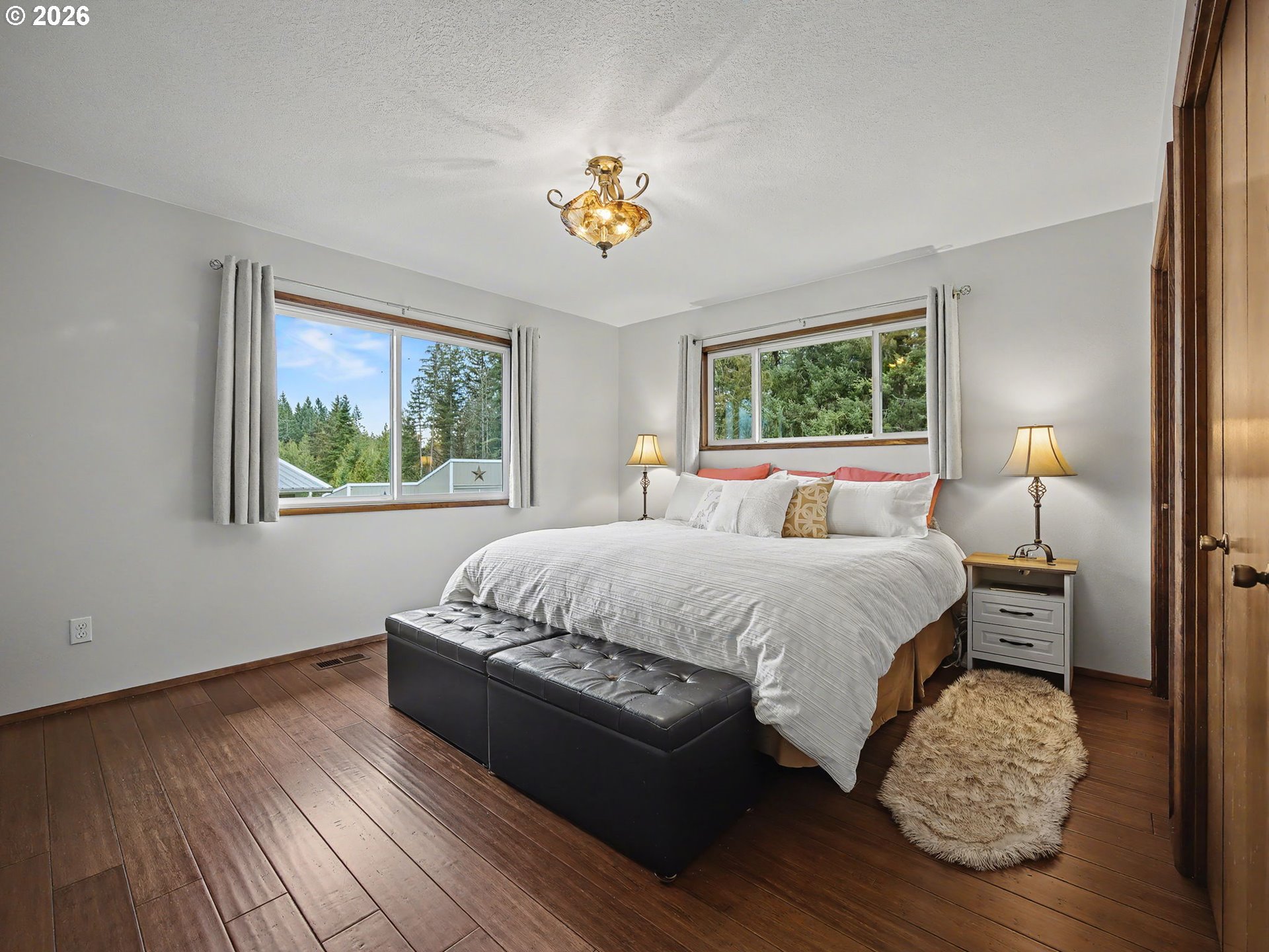 38100 Southeast Trubel Road Sandy, OR 97055 - Photo 18 of 48 a spacious bedroom with a bed and a chandelier