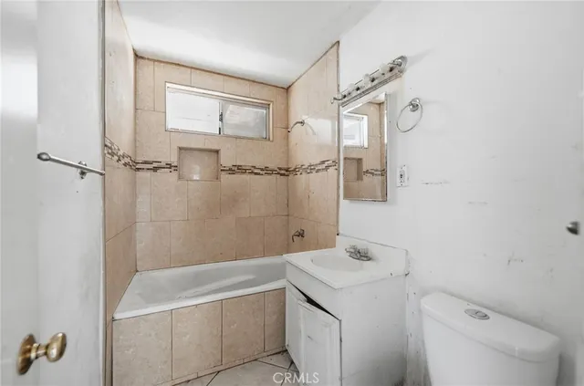 a bathroom with a granite countertop sink a toilet and shower
