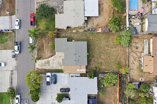 an aerial view of residential houses with outdoor space and parking