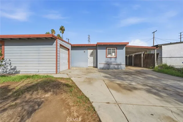 a view of house with backyard and bushes