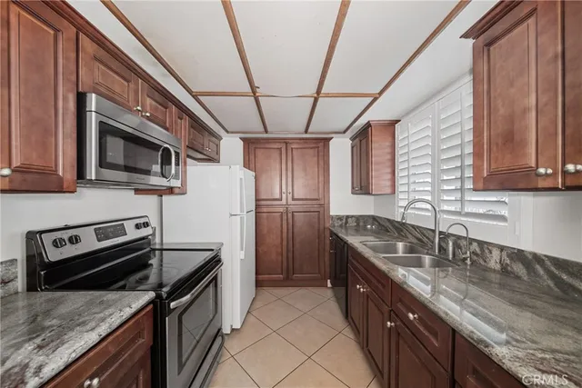 a kitchen with granite countertop a sink stainless steel appliances and cabinets
