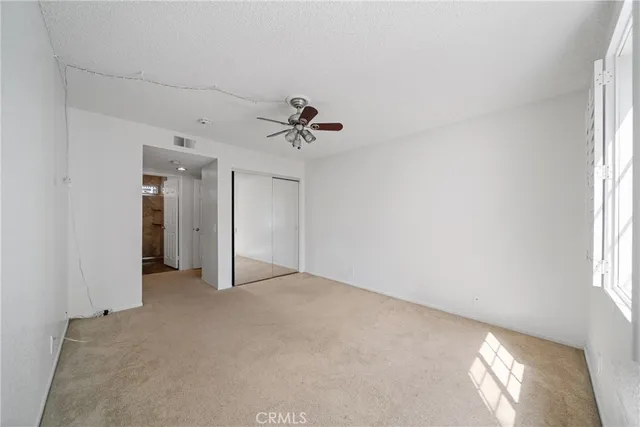 an empty room with fan and windows