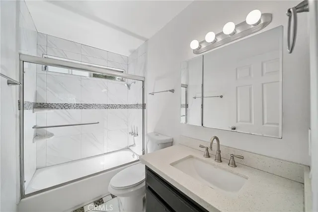 a bathroom with a sink toilet vanity and shower