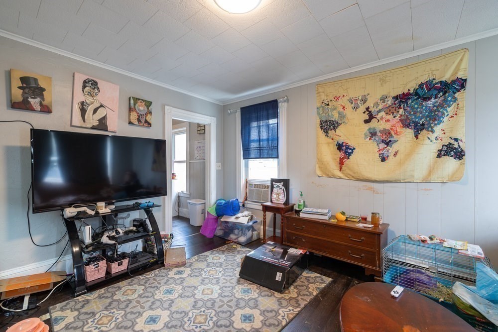 54-56 Stetson Street Whitman, MA 02382 - Photo 20 of 42 a living room with furniture a flat screen tv and a window