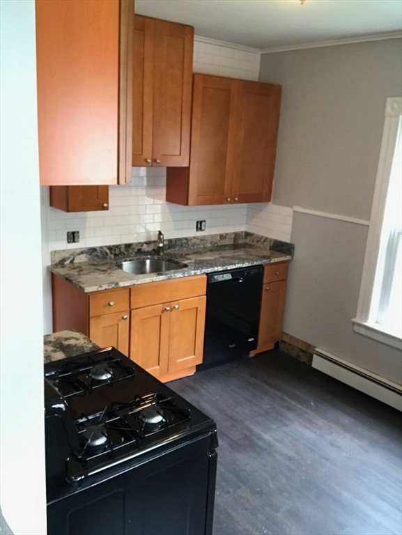 54-56 Stetson Street Whitman, MA 02382 - Photo 22 of 42 a kitchen with stainless steel appliances granite countertop a sink stove and cabinets
