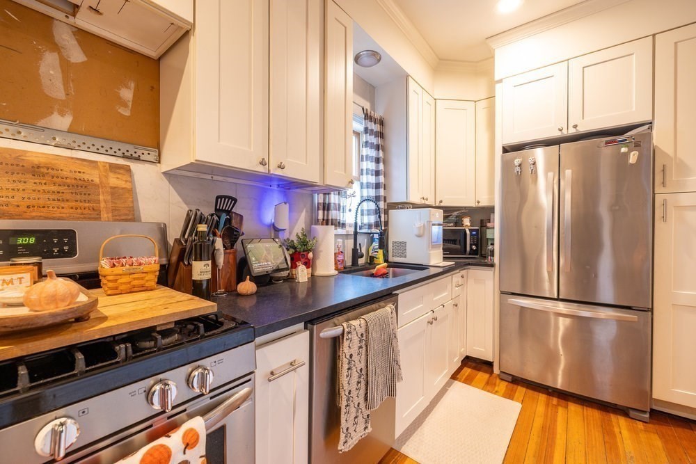 54-56 Stetson Street Whitman, MA 02382 - Photo 7 of 42 a kitchen with stainless steel appliances a refrigerator sink and cabinets