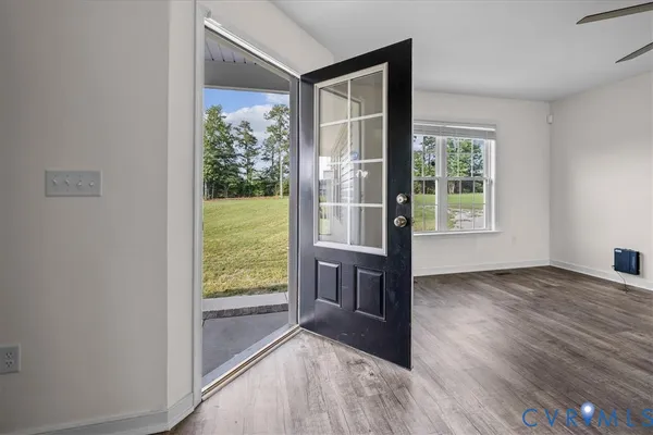 an empty room with wooden floor and windows