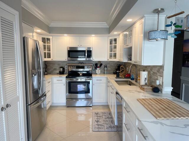 500 Ocean Trail Way, Unit 204 Jupiter, FL 33477 - Photo 3 of 40 a kitchen with stainless steel appliances a refrigerator stove microwave and sink