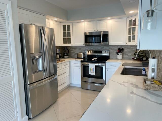 500 Ocean Trail Way, Unit 204 Jupiter, FL 33477 - Photo 4 of 40 a kitchen with stainless steel appliances granite countertop a refrigerator stove a sink and dishwasher