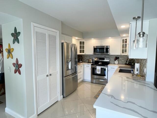 500 Ocean Trail Way, Unit 204 Jupiter, FL 33477 - Photo 5 of 40 a kitchen with stainless steel appliances and refrigerator