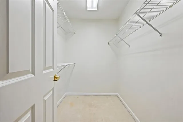 a view of walk in closet with empty racks