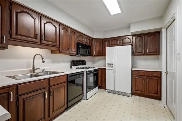 a kitchen with stainless steel appliances granite countertop a refrigerator sink and cabinets