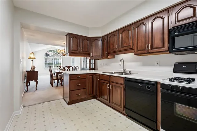 a kitchen with stainless steel appliances granite countertop a stove top oven a sink dishwasher and cabinets with wooden floor