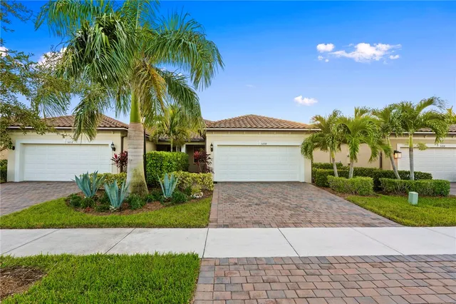 a view of a house with a yard and palm trees