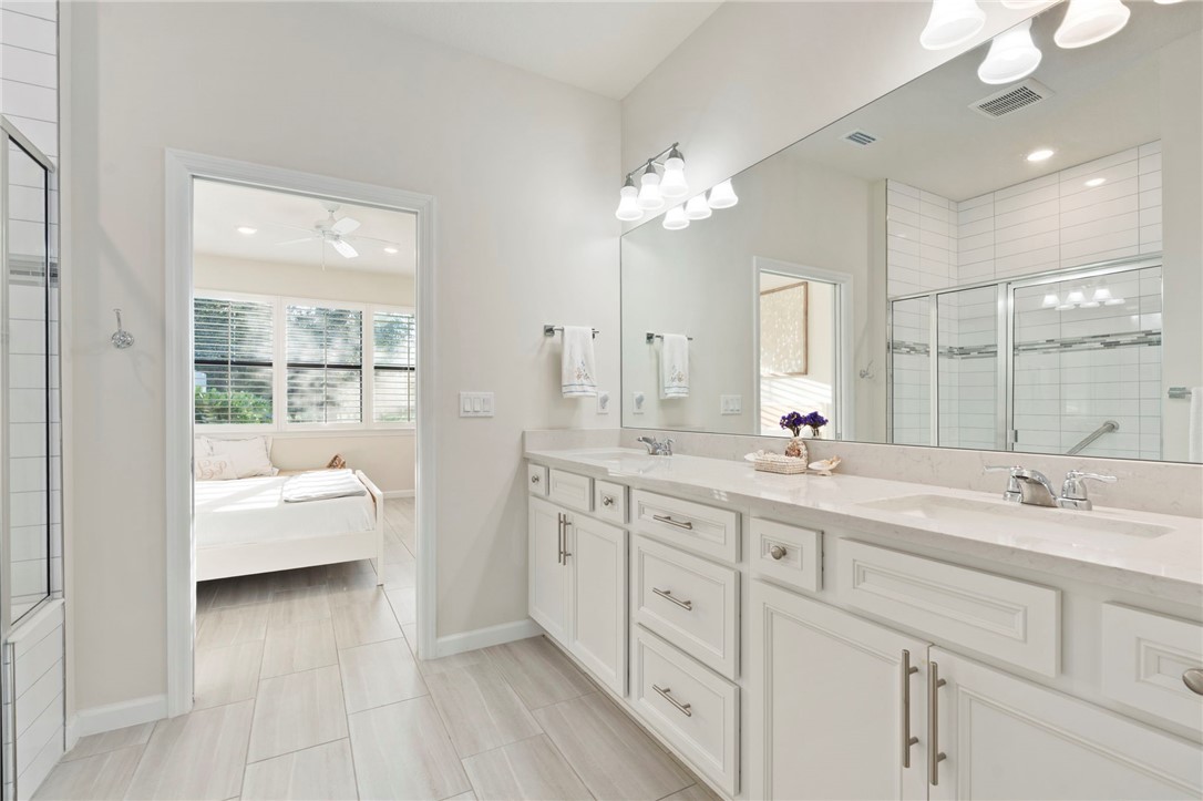 5208 Unity Square Vero Beach, FL 32967 - Photo 20 of 34 a en suite bathroom with double sink and a large mirror