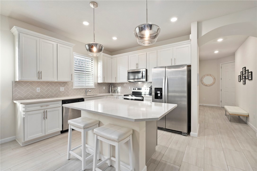 5208 Unity Square Vero Beach, FL 32967 - Photo 7 of 34 a kitchen with refrigerator cabinets dining table and chairs