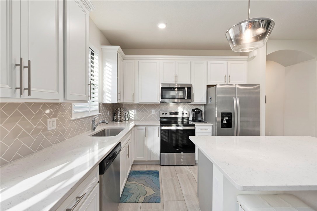 5208 Unity Square Vero Beach, FL 32967 - Photo 8 of 34 a kitchen with stainless steel appliances a sink a stove a refrigerator cabinets and a counter top space