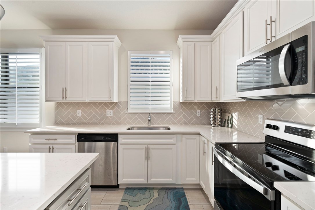 5208 Unity Square Vero Beach, FL 32967 - Photo 9 of 34 a kitchen with a sink stove and microwave