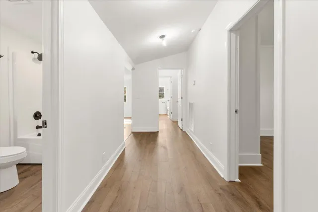 a kitchen with stainless steel appliances granite countertop a sink dishwasher stove and cabinets with wooden floor