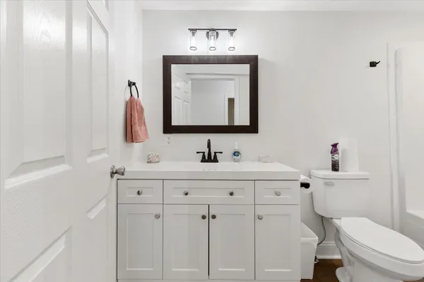 a kitchen with granite countertop a sink stainless steel appliances and white cabinets