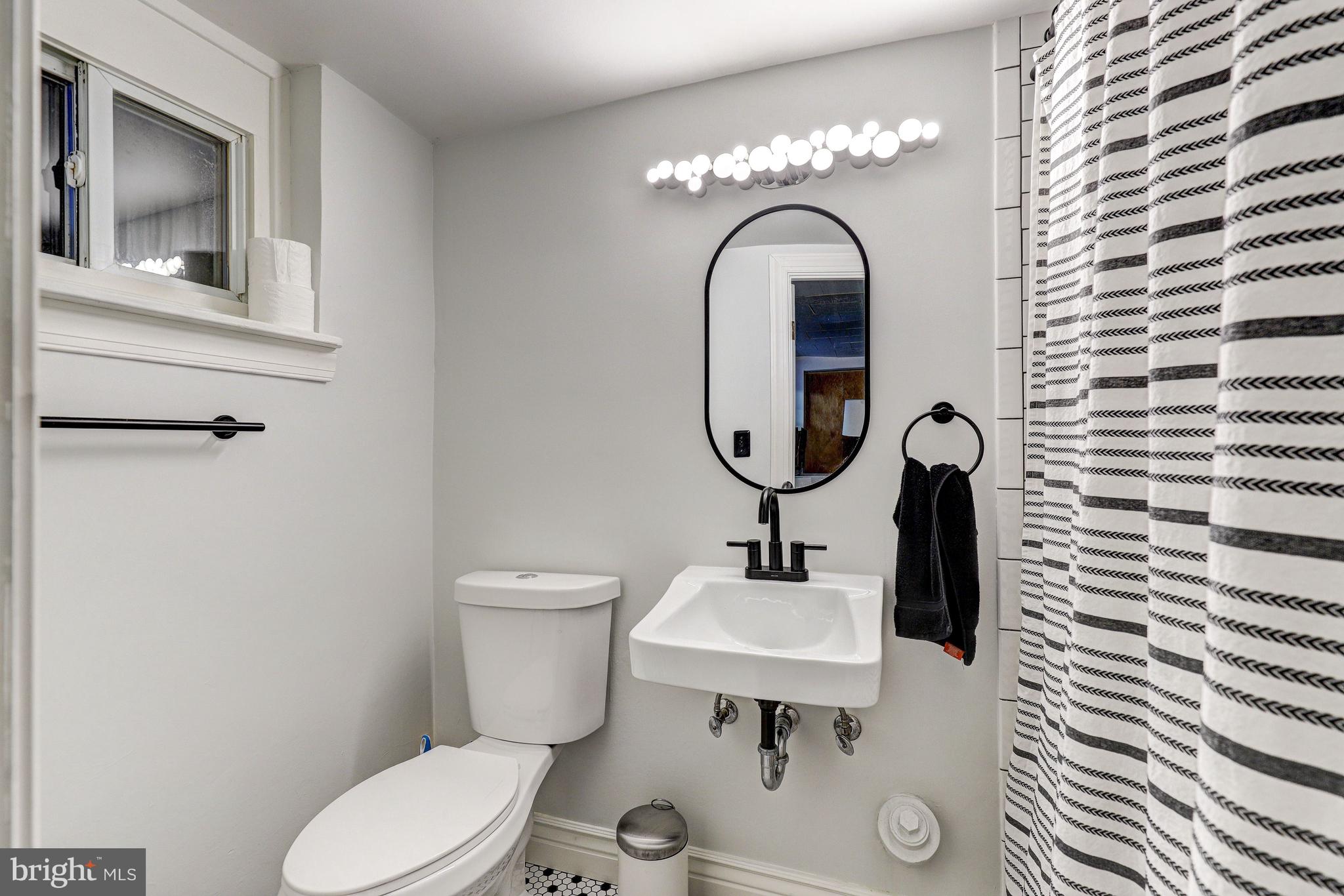 3908 Rexmere Road Baltimore, MD 21218 - Photo 23 of 39 a bathroom with a toilet sink and mirror