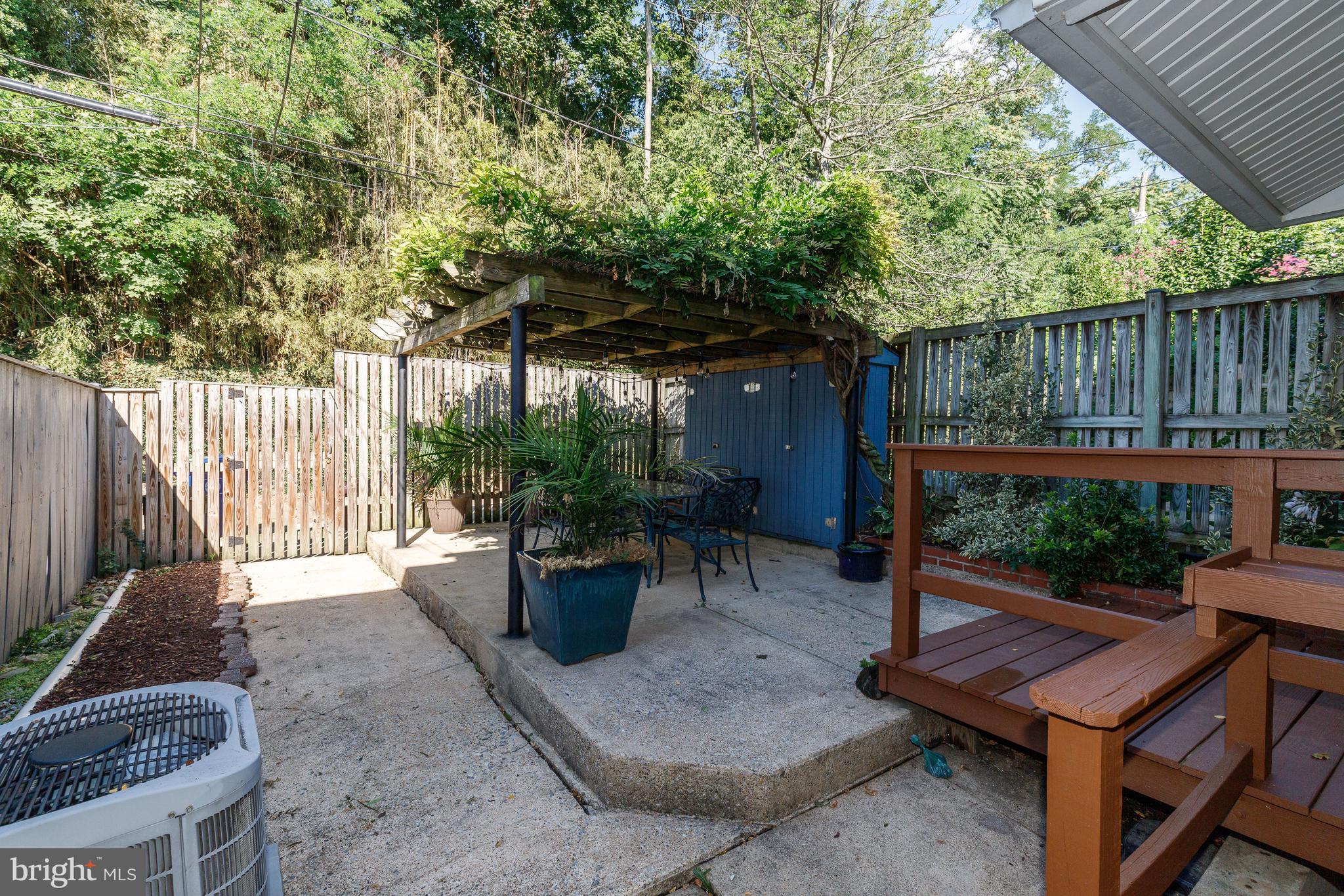 3908 Rexmere Road Baltimore, MD 21218 - Photo 27 of 39 a view of a patio with table and chairs potted plants and wooden fence