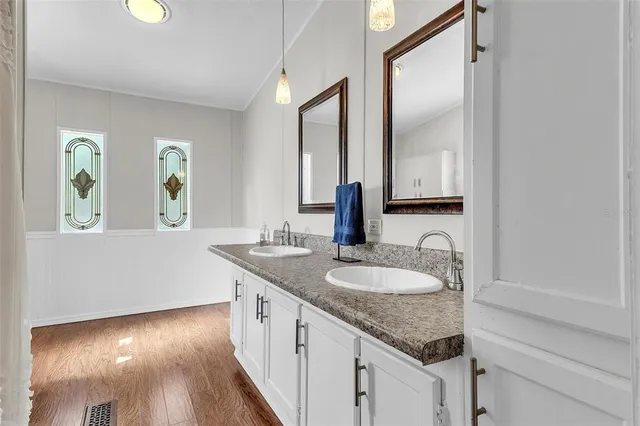 a en suite bathroom with a granite countertop sink and a mirror